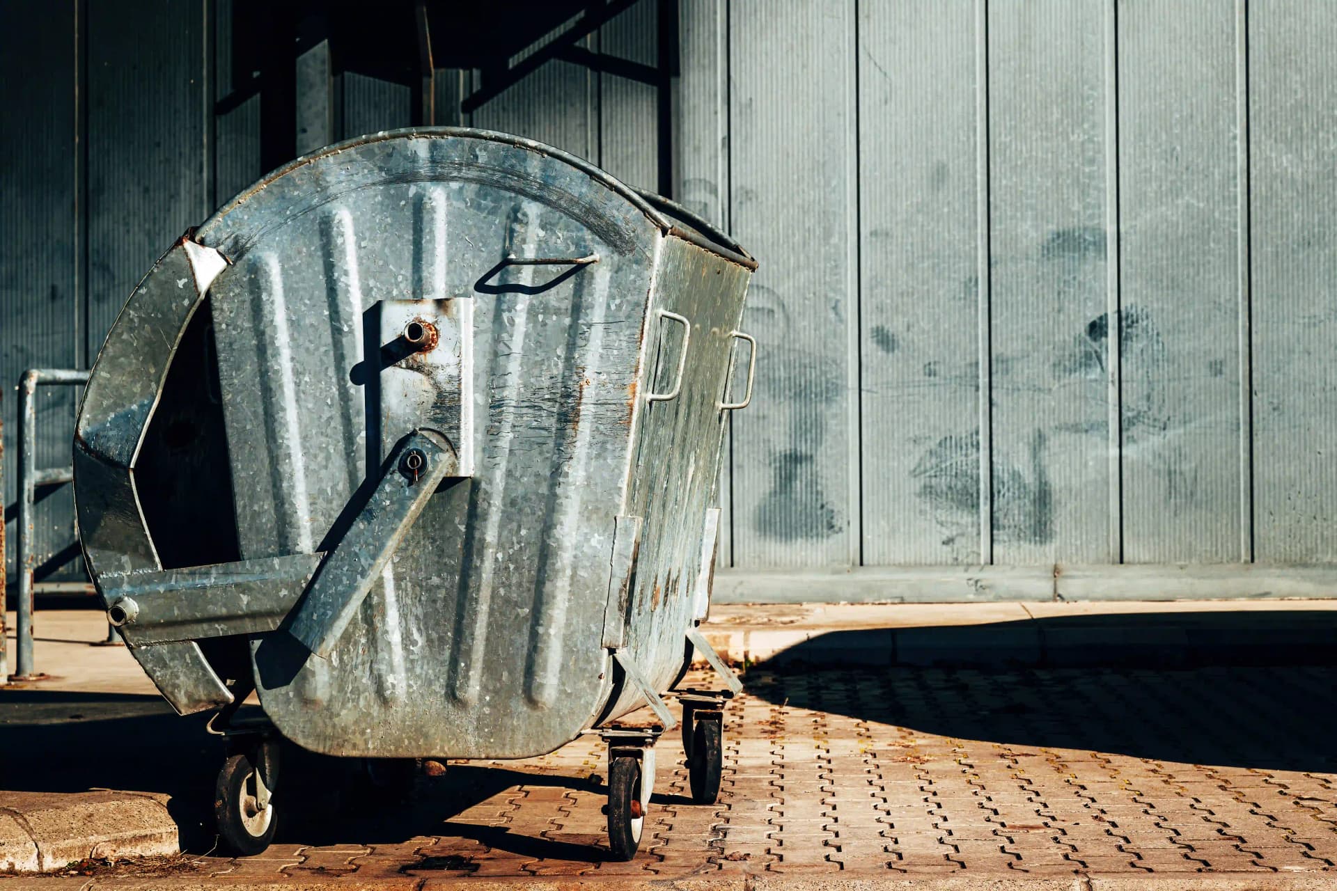 /metallic-trash-dumpster-container-in-front-of-indu